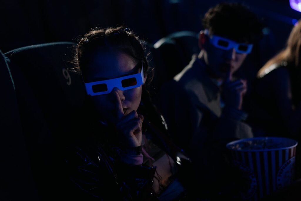Teenagers in a 3D Glasses in a Cinema and Making Hushing Gesture